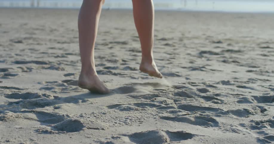 Woman walking barefoot on the sands of a beach