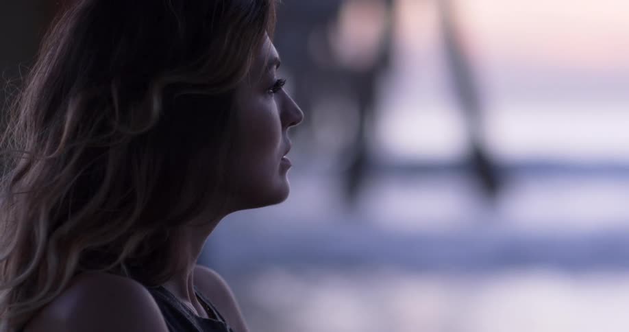 A woman is looking out over the ocean at sunrise