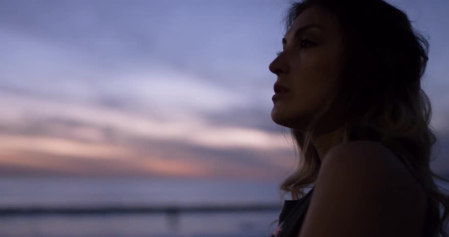 A young woman sits on the beach