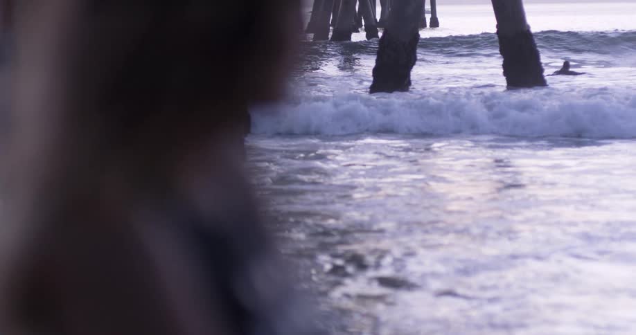 A silhouette in front of crashing waves