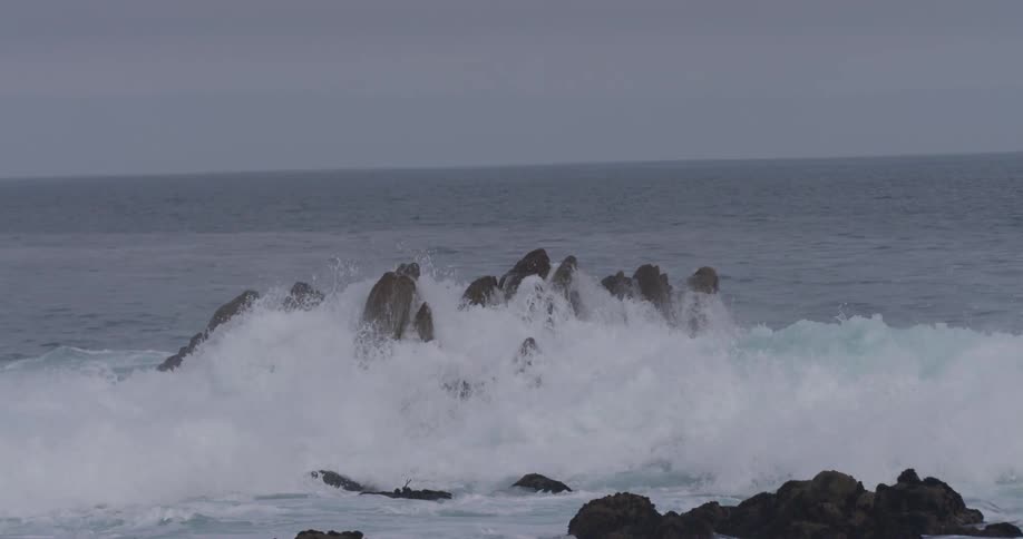 Waves crash over the rocks in the ocean