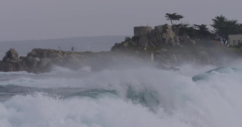 Foamy waves crash over the ocean rocks near the shore