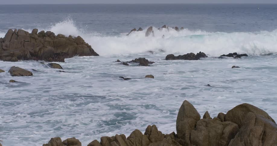 Waves crash against rocks in the ocean and shoreline