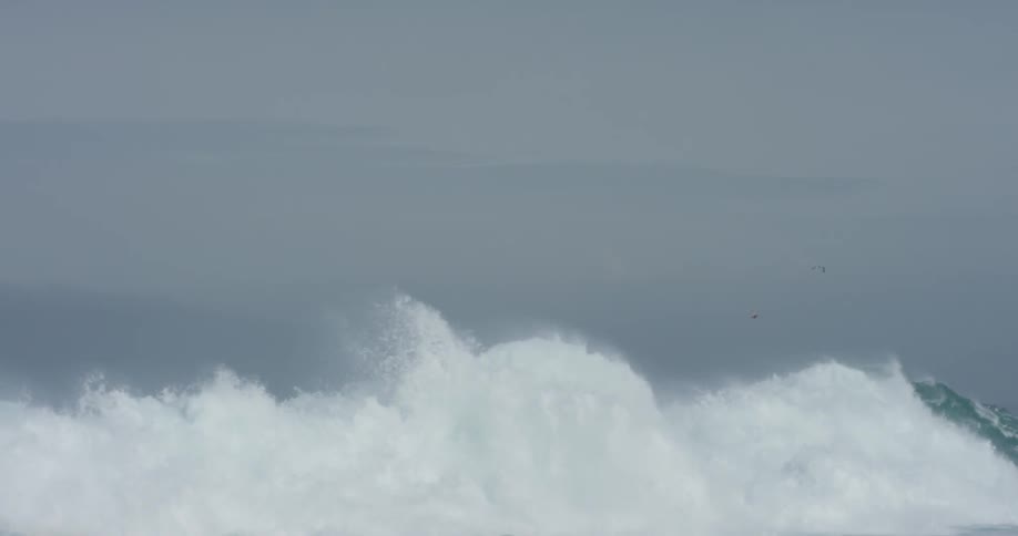 A large ocean wave curls and breaks and splashes