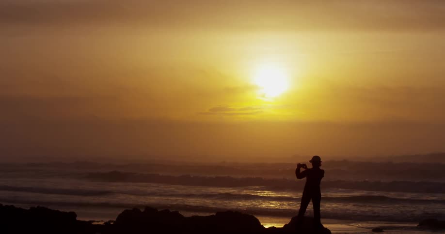 A person standing on the beach looking at the ocean