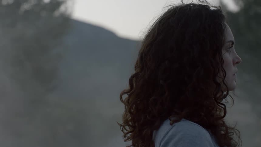 A young woman stands looking off in to the distance
