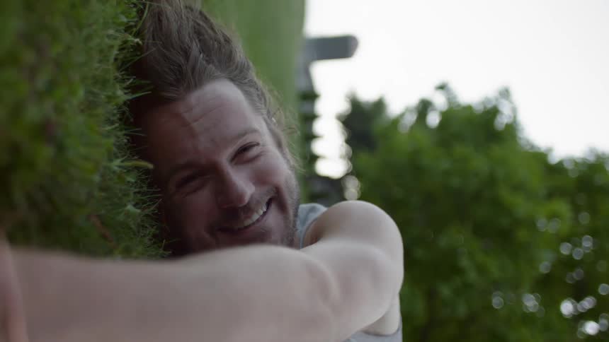 A man lies on the grass laughing