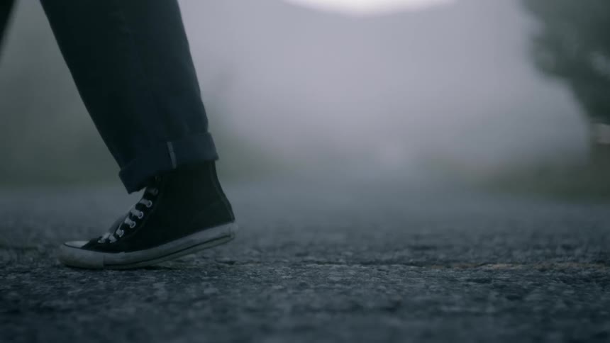 Two people standing back to back on the street then walking away from each other