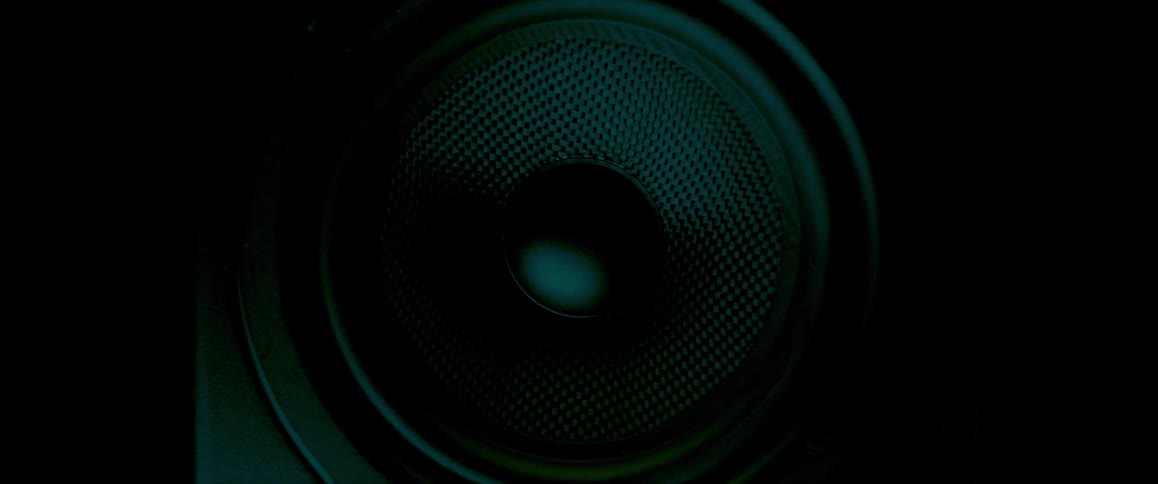 A speaker is vibrating in a dark area