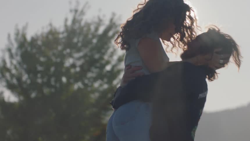 A man picks a woman up and twirls her around