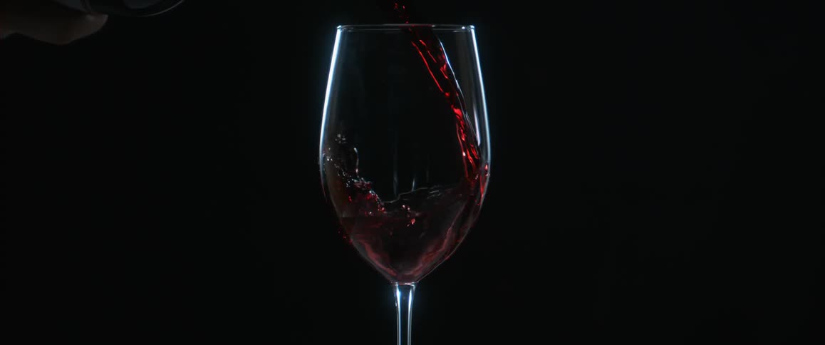 Red wine is poured into a wine glass