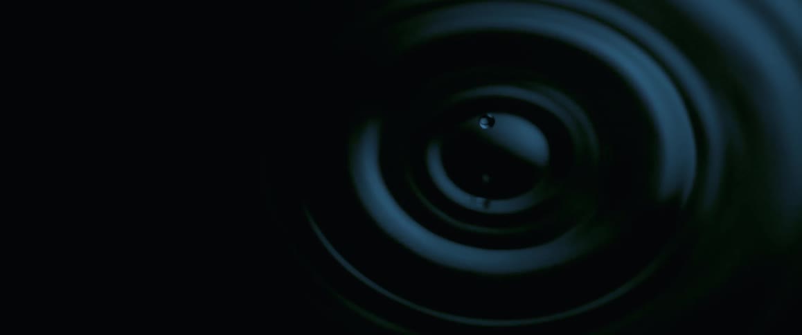 A drop of liquid falls onto the surface causing ripples