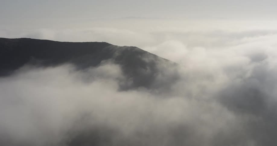 The heavy clouds touch the mountain top