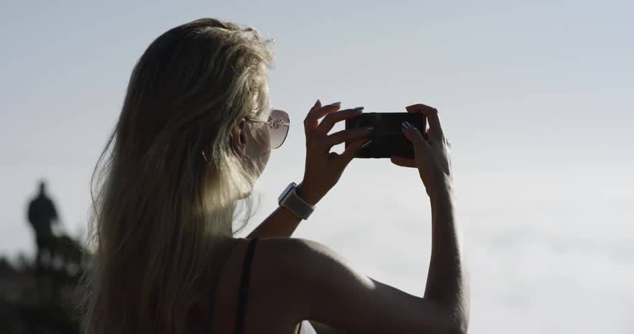 A woman is taking a photo with her phone