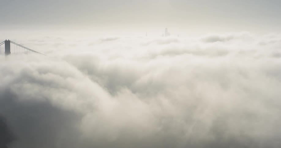 Clouds hang low with a tower and bridge poking through