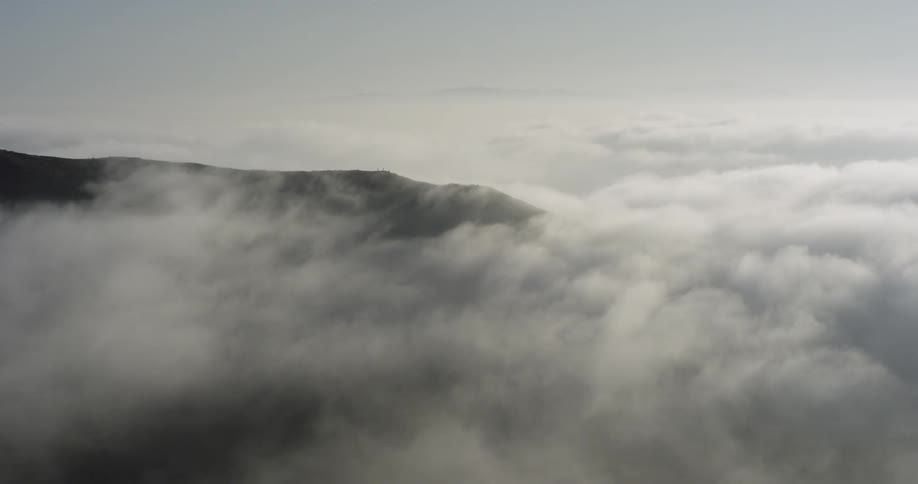 Clouds slowly pass through a mountain scene in daylight