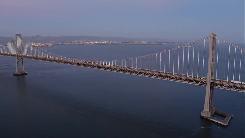 Aerial of a bridge over a body of water with cars traveling on it