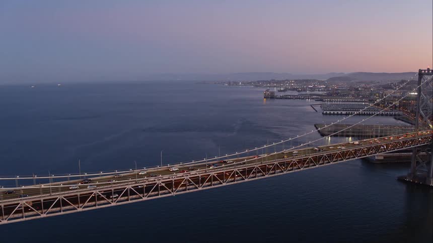 Traffic on a bridge over water at dusk or dawn