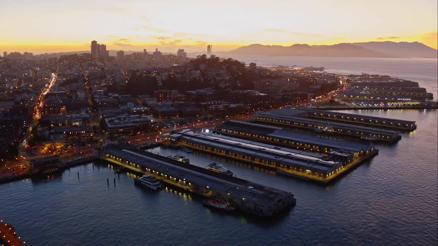 Aerial of metropolis city near the waterfront at sunrise