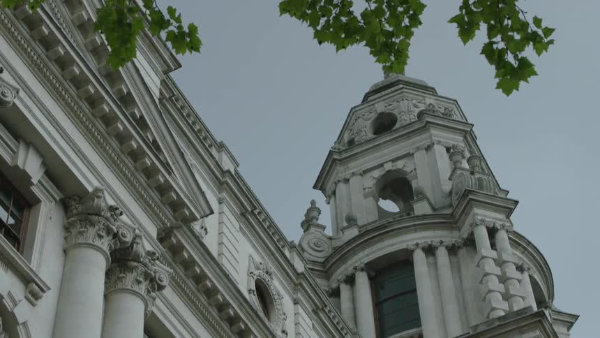 Ornate exterior of a building with a gray sky behind it
