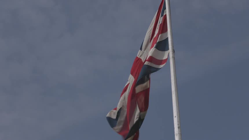 The union jack flag flying against a cloudy sky