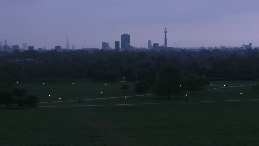 A field of grass before a city at sunset