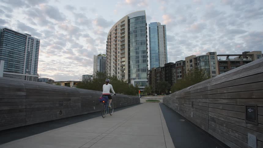 A person is riding a bike toward the city