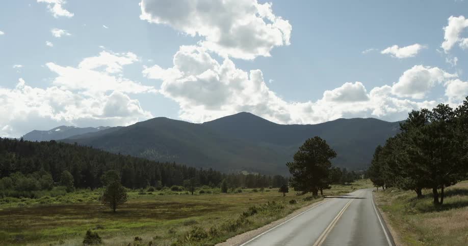 Traveling down a road past mountains