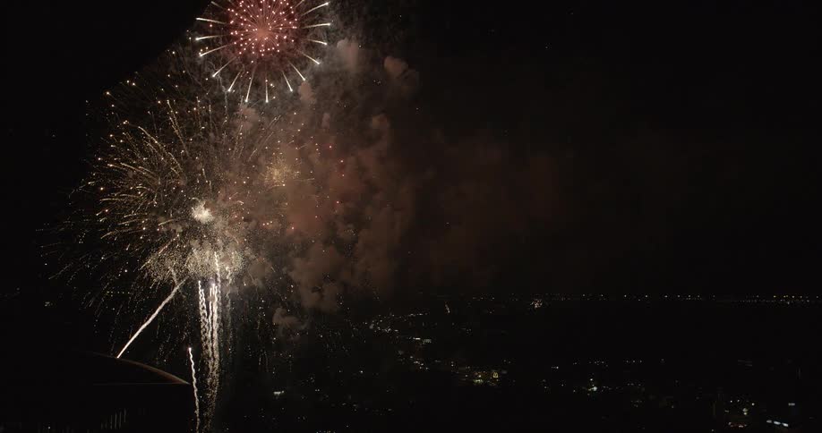 Fireworks shoot into the sky and explode at night