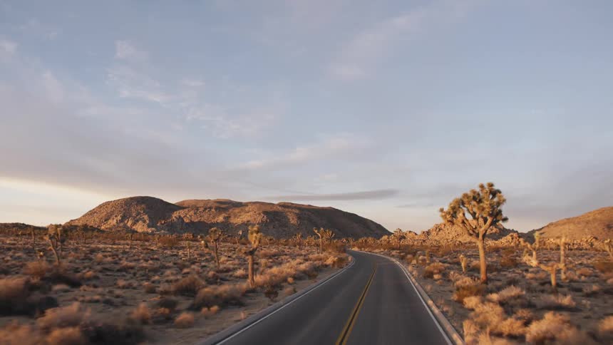 A desert road leads to a rocky hill