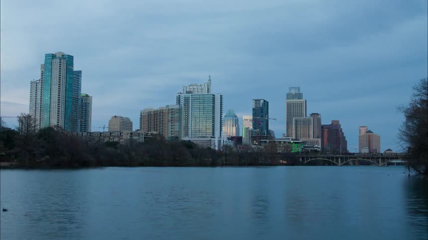 Clouds moving over a busy city as day turns to night