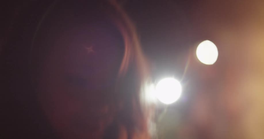 A woman is dancing by a campfire at night