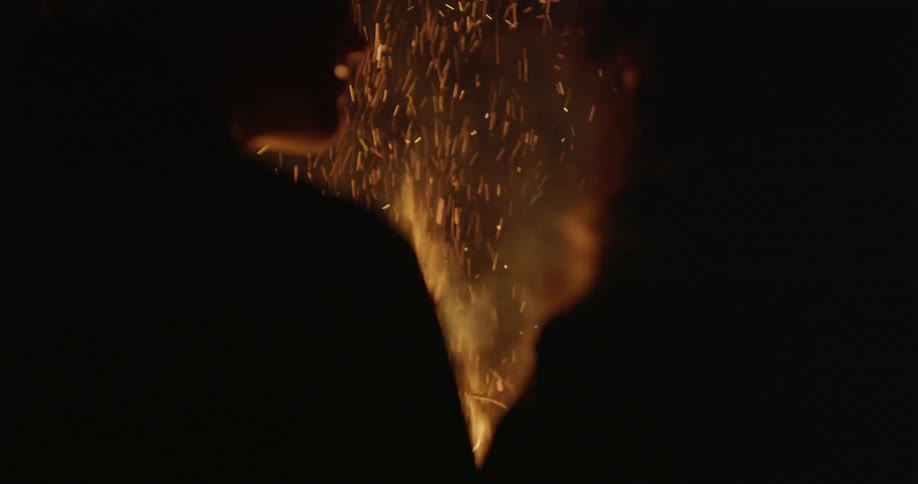 People talking at night in front of bonfire