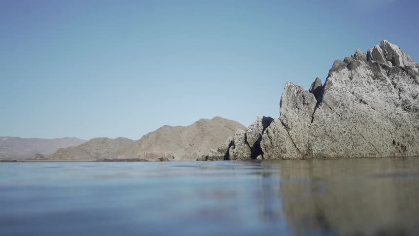 Water is moving against the rocks at midday