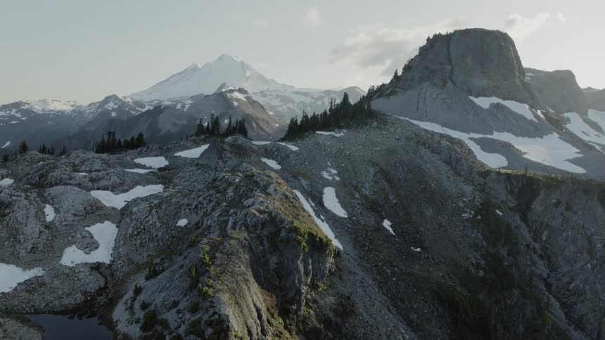 Flying along a deep valley ridge to reveal a rugged mountain range landscape