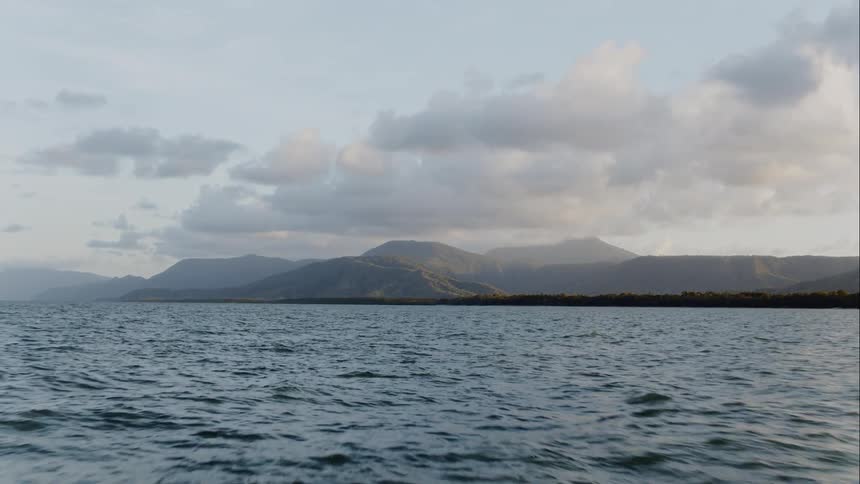 Shot of a moving ocean with a mountain in the background