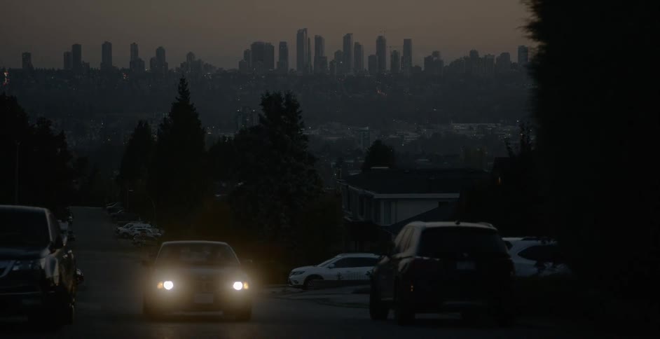 A car is driving on a street at night