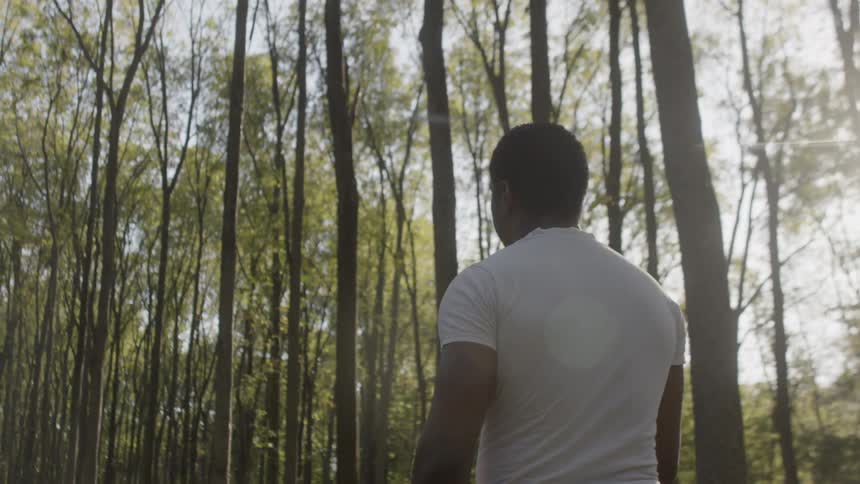 A man walks through a wooded area