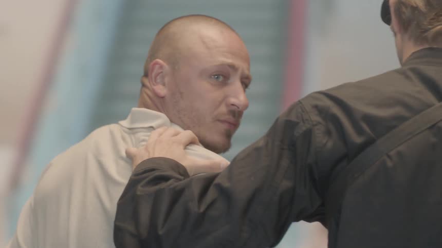 A man is led away by police and turns around to look back