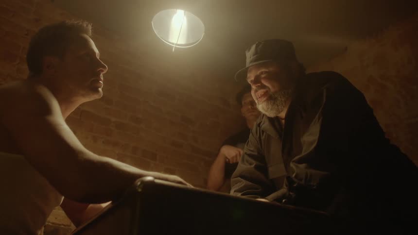 Man with hate interrogates criminal and dark room point at him