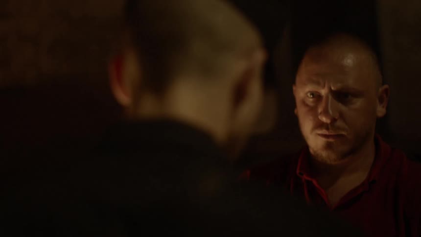 A caucasian man pulling out his wallet while meeting with other man in the dark