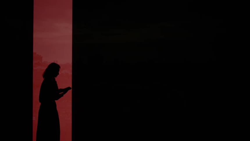 A silhouette of people with a book