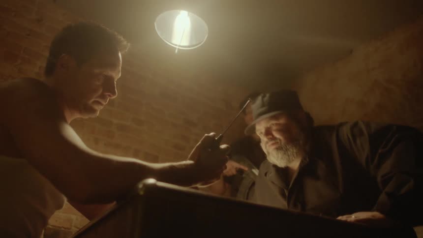 A man being held hostage by two men