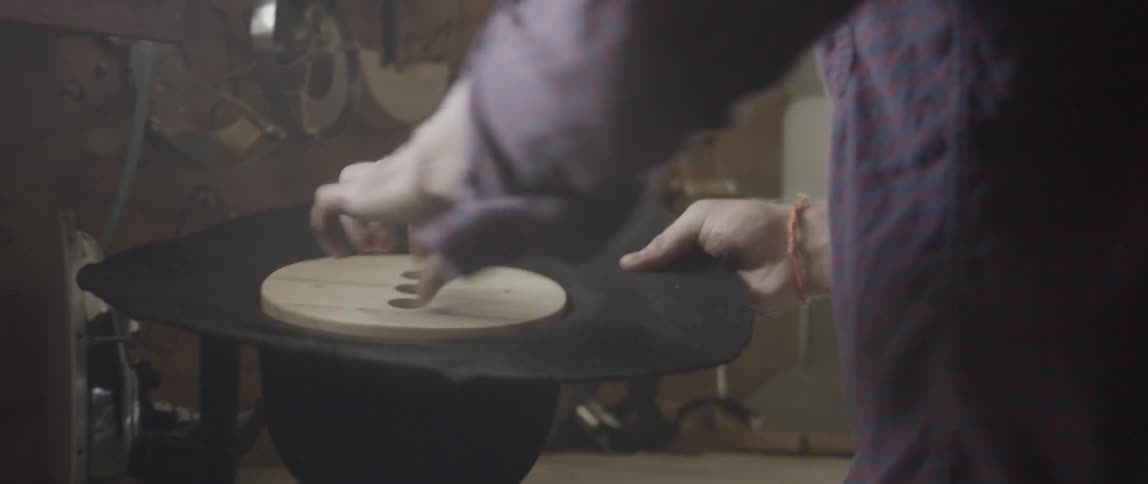 A man shapes a hat