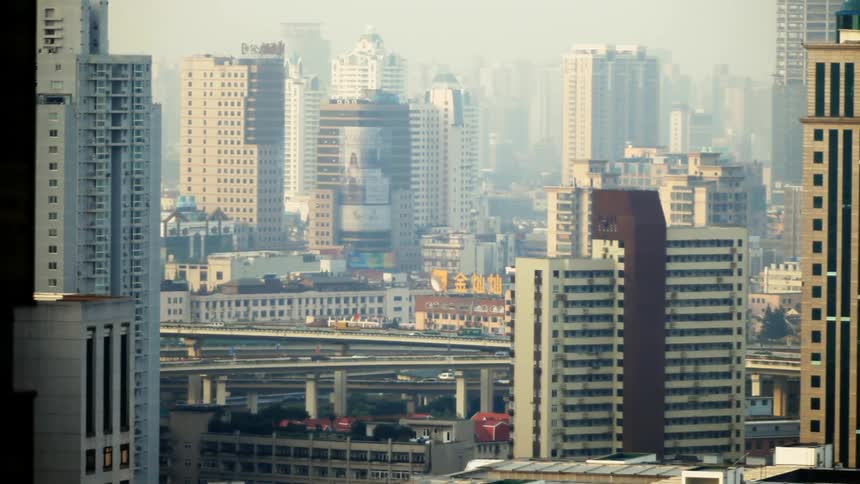 Cars travel on a city highway near skyscrapers