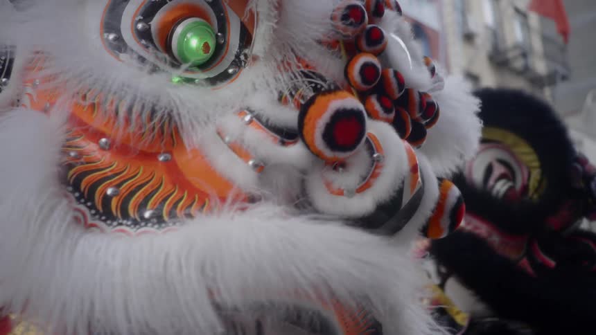 People dressed up in costumes perform a chinese lion dance