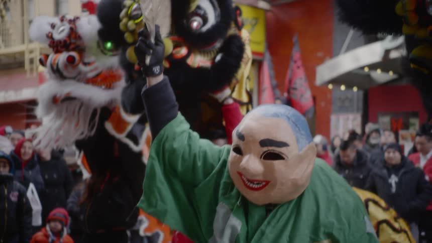 People celebrate wearing costumes in a city street as part of a festival