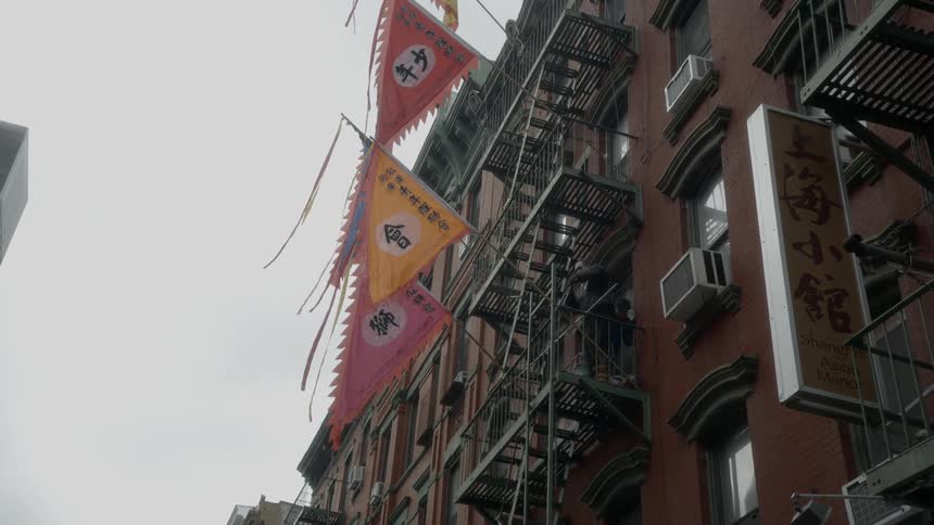 People tying flags on to a balcony