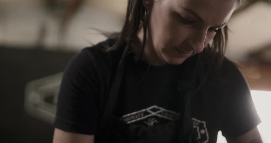 A woman shaving a piece of wood