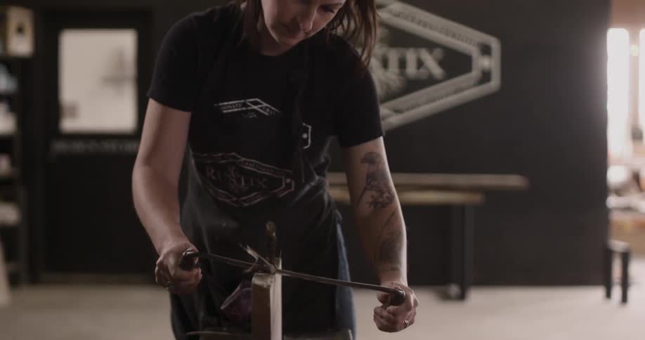A woman working on a piece of wood in a studio
